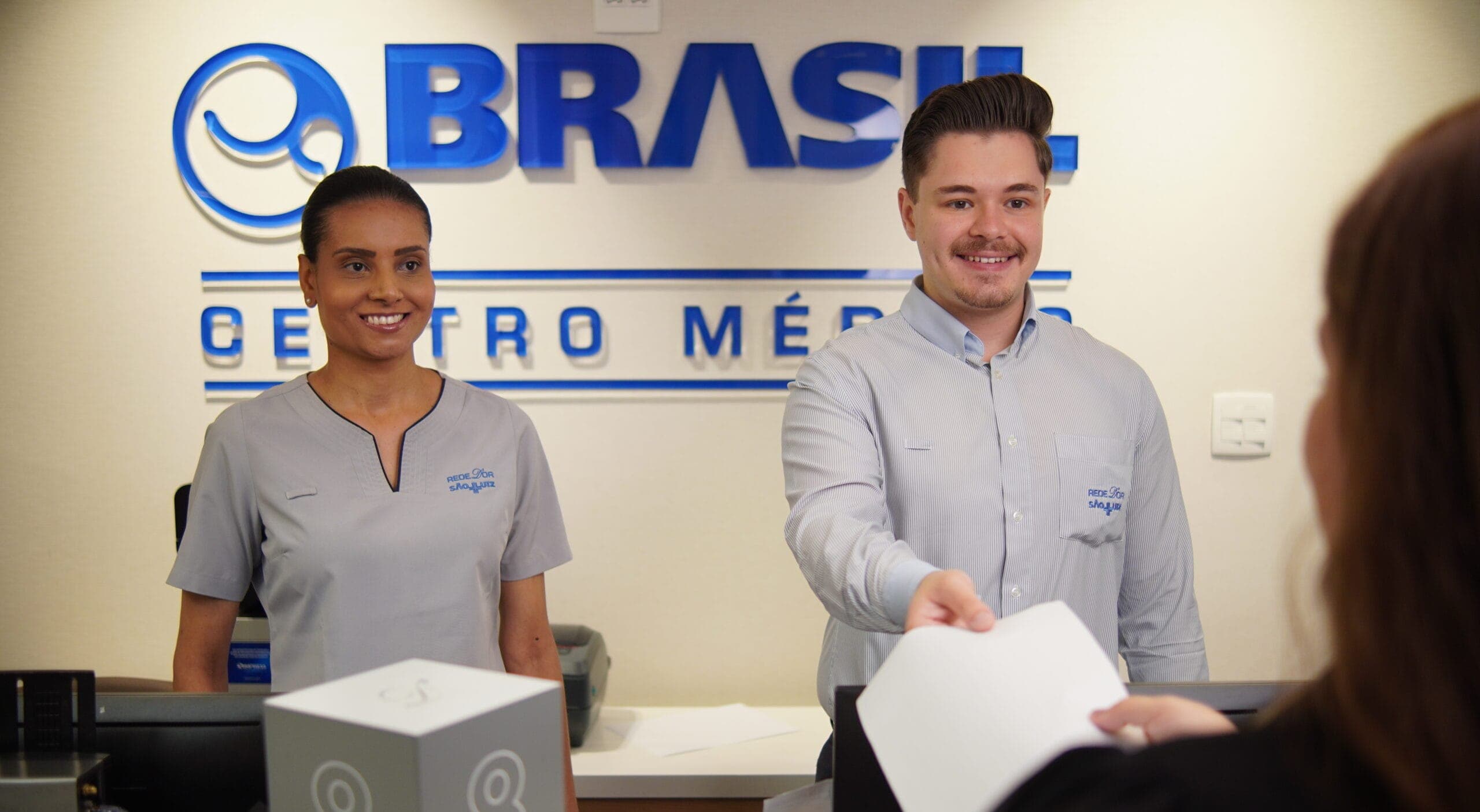 Mulher-negra-Homem-branco-Recepcionistas-Recepc╠oa╠ao-Horizontal-webp_sizes