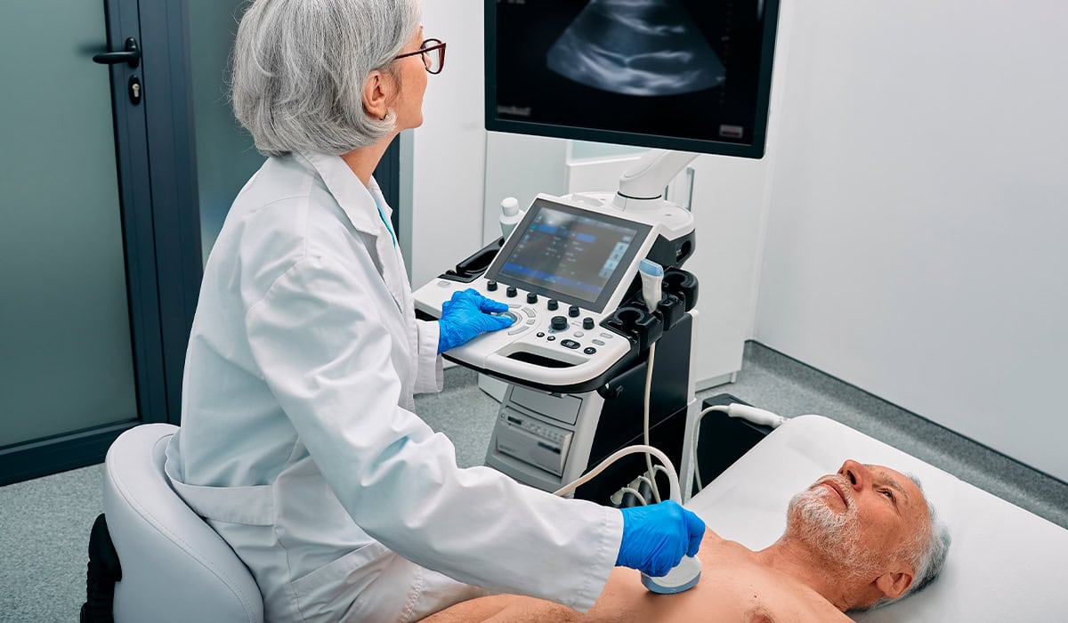 Médica realizando o exame de ecoddoplercardiograma no paciente