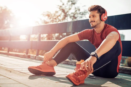 shutterstock_626304002 homem sentado no sol ouvindo musica