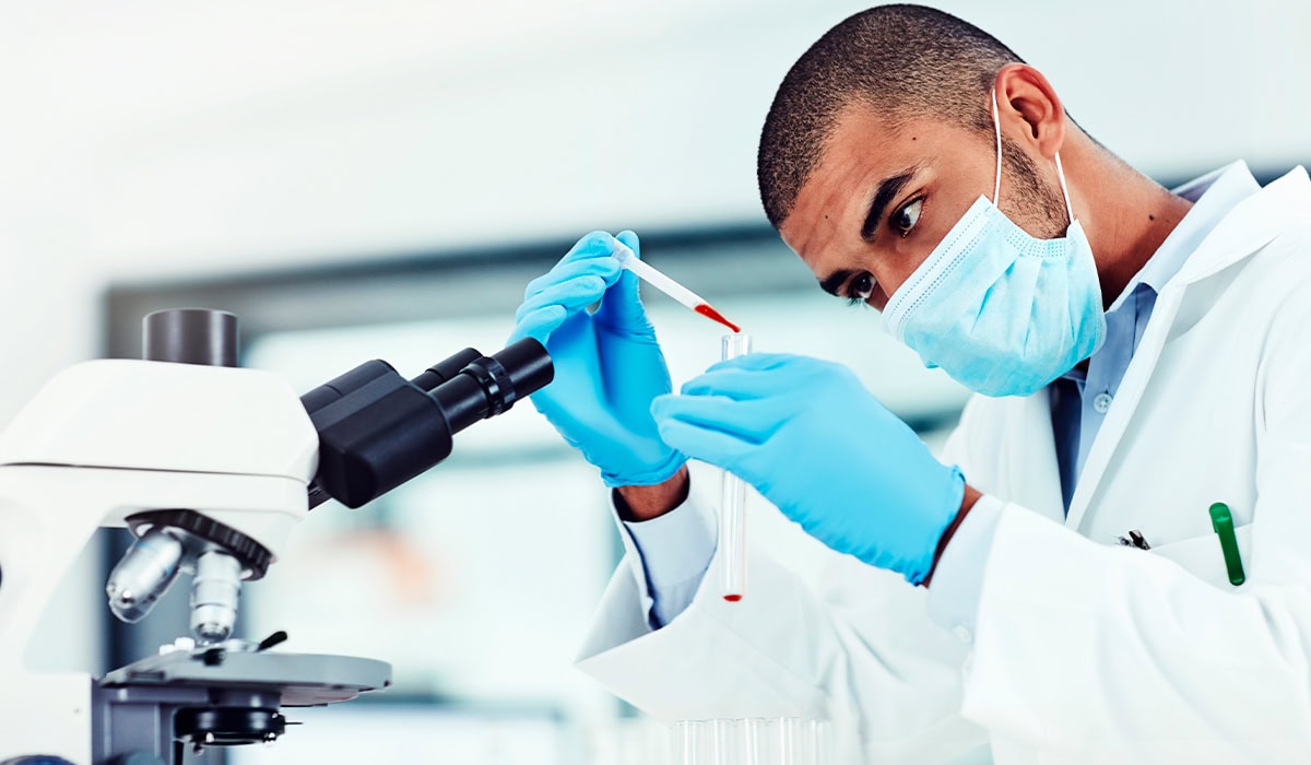 Tubo de exame de sangue sendo analisado por técnico de análises clínicas
