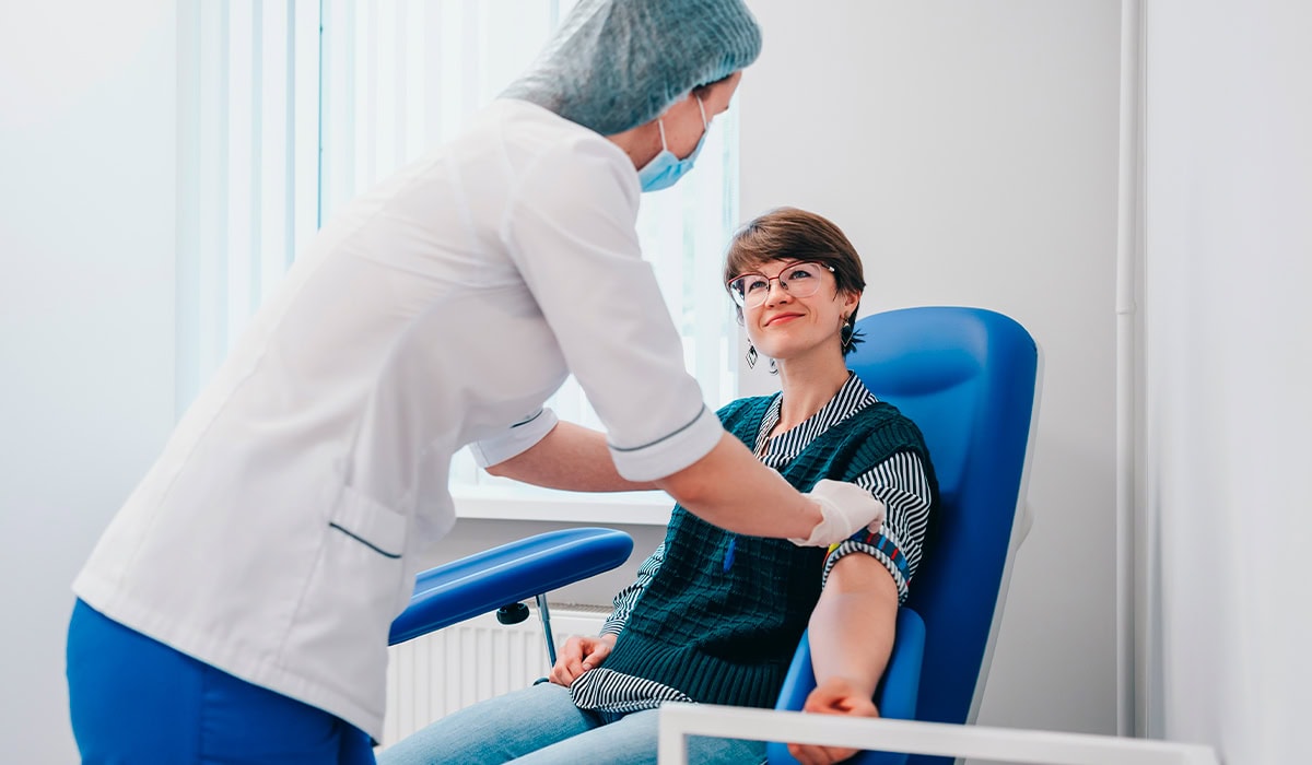 Enfermeira da Rede D'Or colhendo sangue de paciente para exame de sangue de GGT