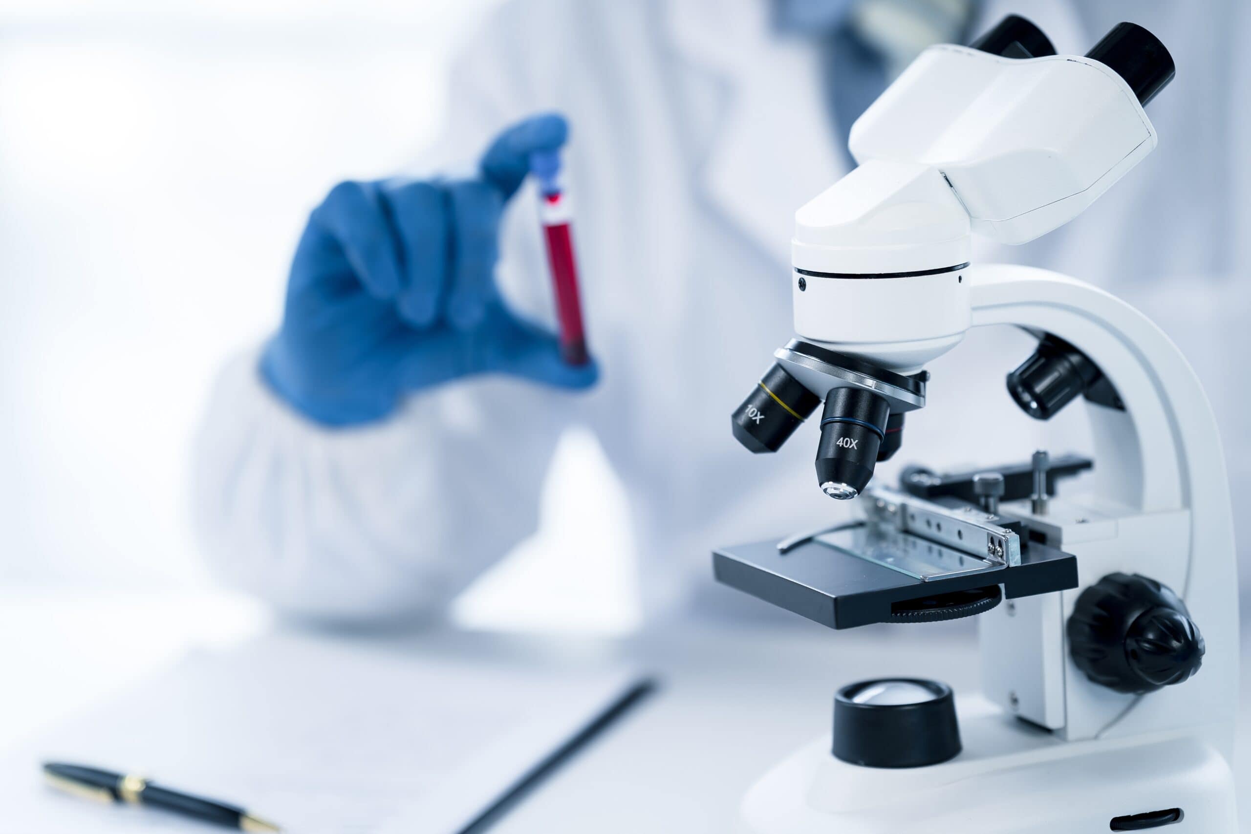 Médica manuseando tubo de ensaio com sangue Médica manuseando tubo de ensaio com sangue