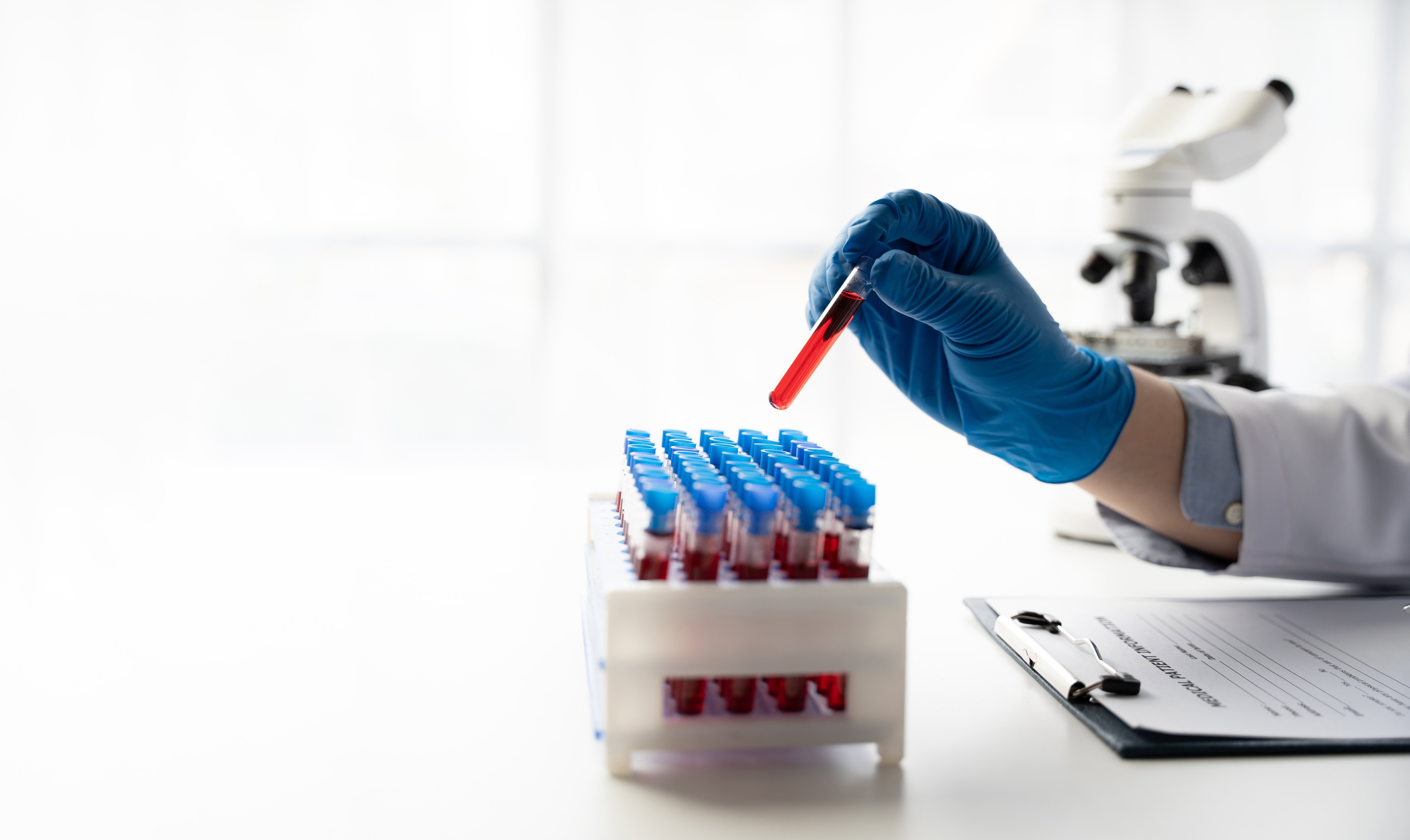 Profissional segura tubo de ensaio com amostra em laboratório. Profissional segura tubo de ensaio com amostra em laboratório.