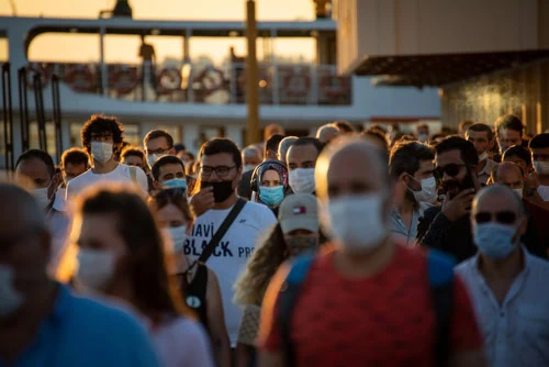 People,Disembarking,From,The,City,Lines,Ferry,Docking,At,Kadikoy Várias pessoas de máscara andando na rua. Imagem meramente ilustrativa. Uso editorial