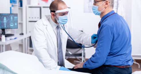 medico examina coração de paciente com estetoscópio