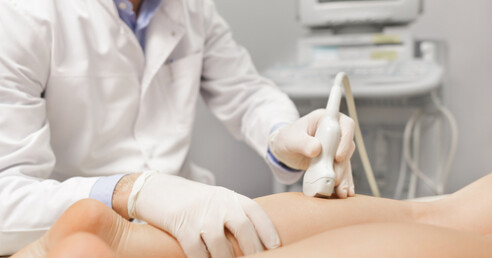 médico faz ultrassom na perna de paciente