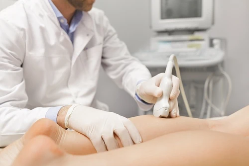 médico faz ultrassom na perna de paciente