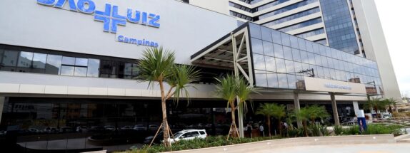 Fachada cinza e de vidros espelhados com a logo do Hospital e Maternidade São Luiz Campinas em azul.
