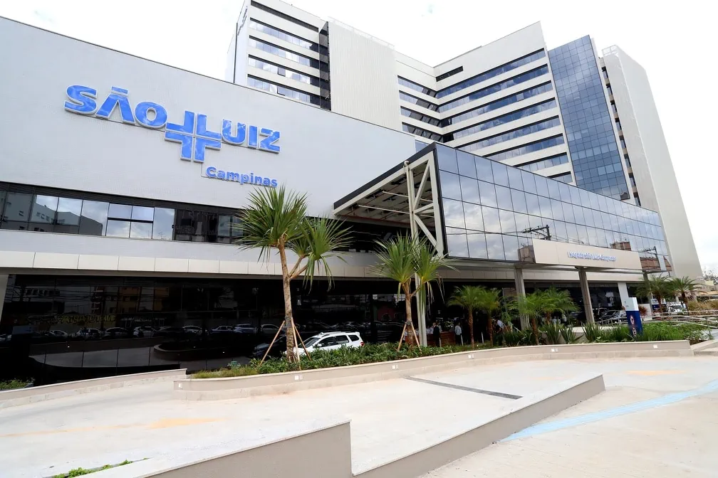 Fachada cinza e de vidros espelhados com a logo do Hospital e Maternidade São Luiz Campinas em azul.