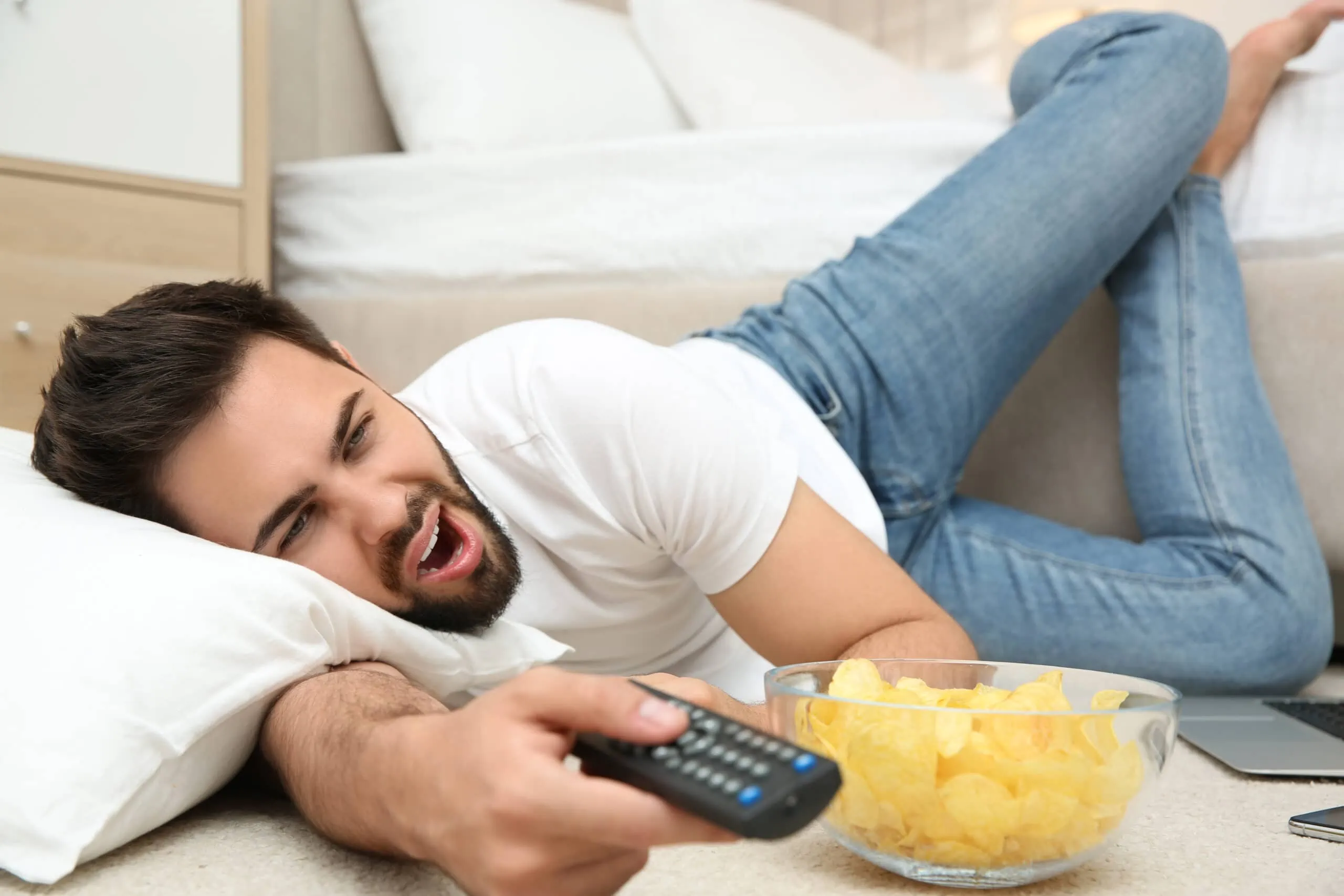 Lazy,Young,Man,With,Bowl,Of,Chips,Watching,Tv,While