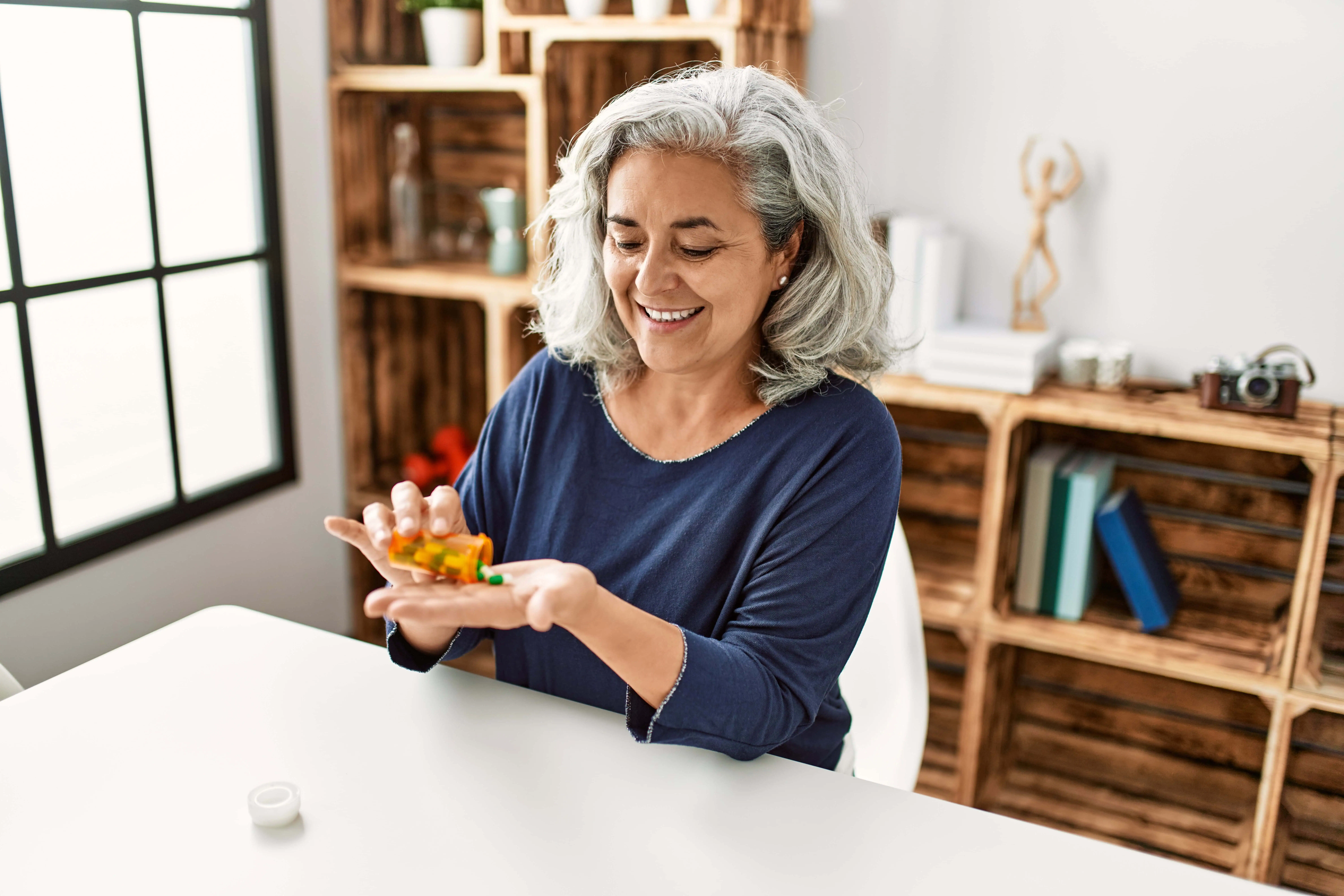 Middle,Age,Grey-haired,Woman,Taking,Pills,Sitting,On,The,Table