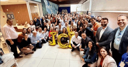 pessoas comemoram com balões que formam a palavra JCI