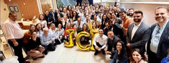 pessoas comemoram com balões que formam a palavra JCI