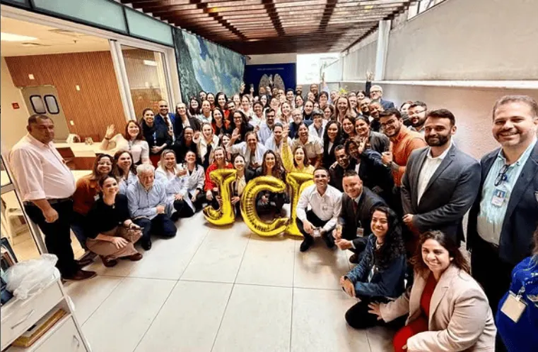 pessoas comemoram com balões que formam a palavra JCI