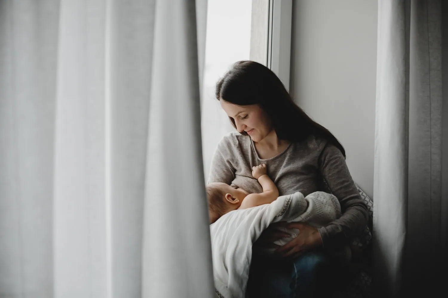 ALT: uma mãe amamentando o seu bebê.